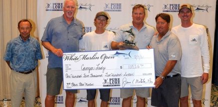 group of men holding check for winning third place in the blue marlin category